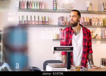 Propriétaire de sexe masculin à la voiture tandis que l'article en magasin de bonbons Banque D'Images