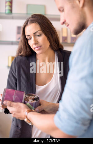 Travailleur masculin avec collègue vérification de produit en magasin de bonbons Banque D'Images