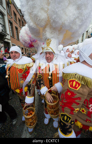 Gilles portant des coiffes d'autruche et transportant des oranges lors d'une procession dans le streetsat la Binche Carnaval, Binche, Belgique Banque D'Images