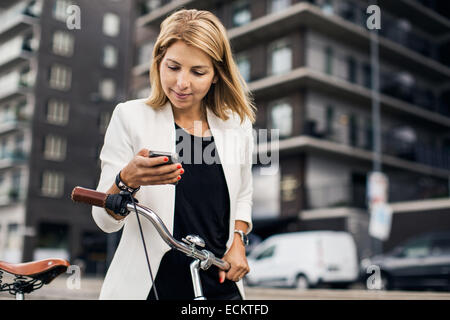 Businesswoman using smart phone in city Banque D'Images