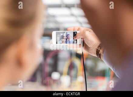 Les gens d'affaires prenant en selfies smart phone in cafe Banque D'Images