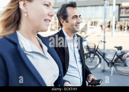 Businesspeople looking away en marchant sur la rue Banque D'Images