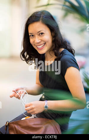 Vue de côté portrait de femme assise au shopping mall Banque D'Images