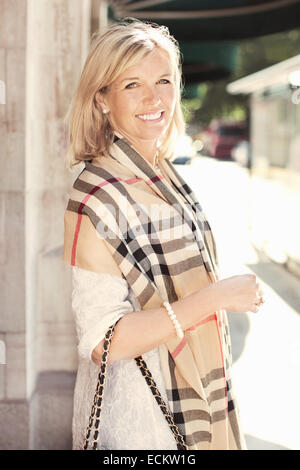 Side view portrait of happy woman standing on sidewalk Banque D'Images