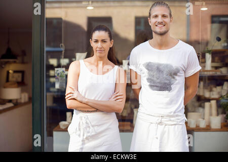 Portrait of smiling workers standing extérieur atelier vaisselle Banque D'Images