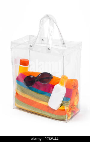 Sac en plastique transparent avec des accessoires de plage, isolé sur blanc. Banque D'Images