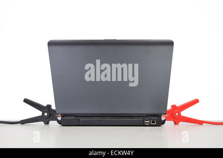 Ordinateur portable est en charge par câbles de pontage sur table. Banque D'Images