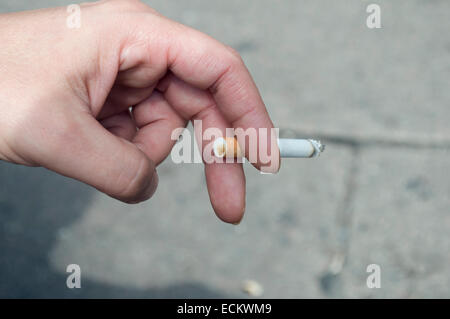 Close-up of a woman's hand holding une cigarette à l'extérieur Banque D'Images