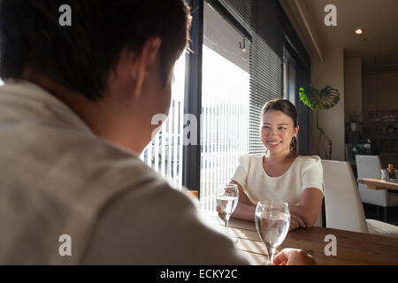 Femme et homme assis à une table dans un café, souriant. Banque D'Images