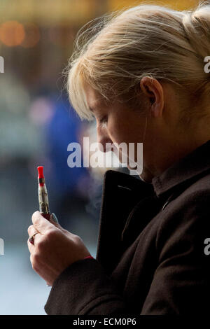 London UK. 16 décembre. Un employé de bureau exhale la vapeur comme elle fume une cigarette au cours E sa pause déjeuner dans le crédit temps froid : amer ghazzal/Alamy Live News Banque D'Images