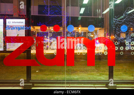 Le transport en commun rapide Züm logo avec les lumières de Noël reflète dans la vitre. Le centre-ville de Brampton, Ontario, Canada. Banque D'Images