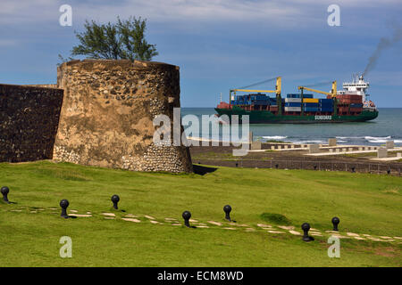 Porte-conteneurs entrant dans la baie de Puerto Plata et le port avec des murs de la forteresse de San Felipe à République Dominicaine Banque D'Images