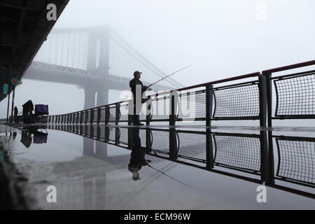 Pêche à l'homme de l'Est River Esplanade sur un matin brumeux à New York City Banque D'Images