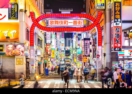 Les piétons à pied ci-dessous densément signe une ruelle doublure dans le Kabuki-cho, Tokyo, Japon. Banque D'Images