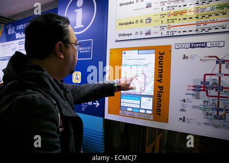 Un homme utilise un passage inférieur de l'écran tactile d'information planificateur de voyage 'guide' à la Gare de Ueno, le 17 décembre 2014 à Tokyo, Japon. L'écran tactile de l'information apporte des lignes de métro de Tokyo en anglais, japonais, chinois et coréen. Le métro de Tokyo société prépare un guide d'utilisation et Informations touristiques sur différentes stations pour les Jeux Olympiques de Tokyo en 2020. © Rodrigo Reyes Marin/AFLO/Alamy Live News Banque D'Images