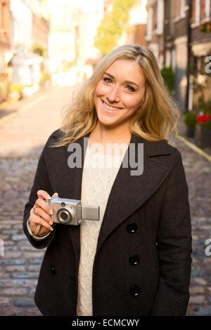 Young woman holding a camera Banque D'Images