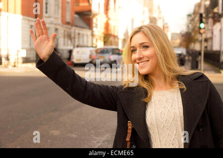 Jeune femme héler un taxi. Banque D'Images