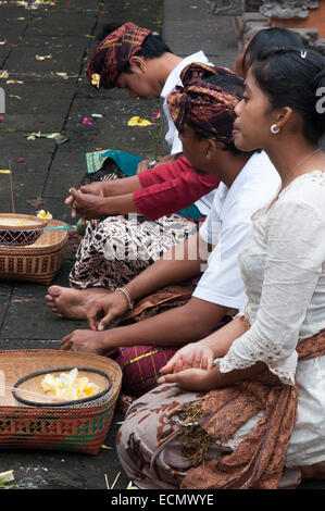 Une famille balinaise prie à PURA TIRTA EMPUL temple hindou et un complexe de sources froides - TAMPAKSIRING, BALI, INDONÉSIE. Plusieurs personnes Banque D'Images