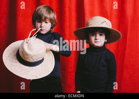 Portrait de deux garçons portant des vêtements noirs et un chapeau de paille Banque D'Images