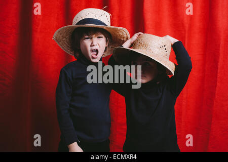 Portrait de deux garçons portant des vêtements noirs et un chapeau de paille Banque D'Images