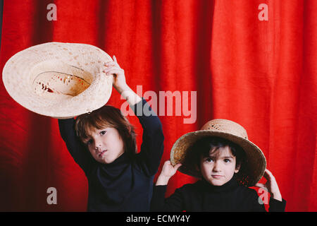 Portrait de deux garçons portant des vêtements noirs et un chapeau de paille Banque D'Images