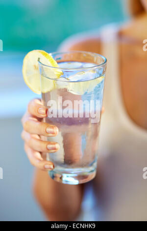 Fille de boire dans un verre d'eau glacée au citron Banque D'Images