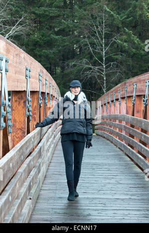 Asian senior woman in Juneau, Alaska sur Fish Creek Trail, Douglas Island. Senior emmitouflés dans des vêtements pour temps froid. Banque D'Images