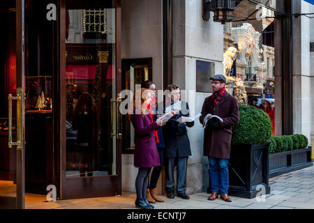 Carol Singers effectuer à l'extérieur de la boutique Ralph Lauren à New Bond Street, Londres, Angleterre Banque D'Images