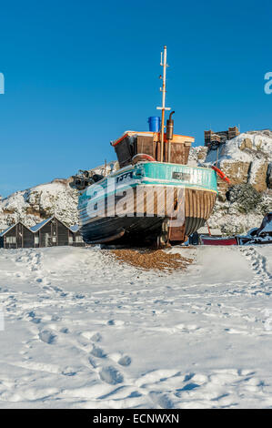 Les bateaux de pêche amarrés sur Hastings plage stade après une chute de neige. East Sussex. UK Banque D'Images