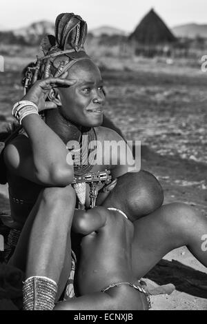 Femme Himba nourrir son bébé Banque D'Images