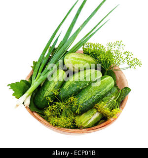 Les concombres et les légumes et les feuilles d'aneth, encore en vie bol en bois isolé sur fond blanc. Libre Banque D'Images