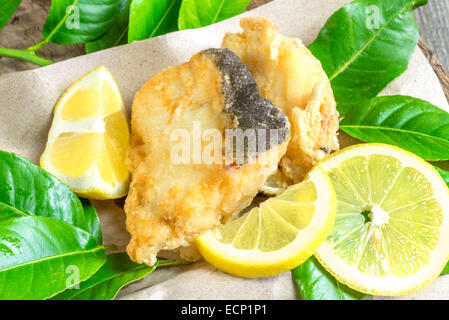 Morceau de cabillaud frits sur feuilles de citron Banque D'Images