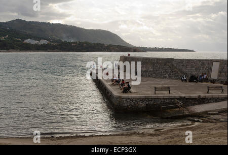 CEFALU, SICILE, ITALIE - 2 octobre 2012 : les gens assis sur le quai de la ville au coucher du soleil, le 2 octobre 2012 à Cefalu, Sicile, je Banque D'Images