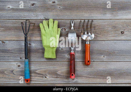 Outils de jardin et des gants utilisés sur les planches de bois rustique. Banque D'Images