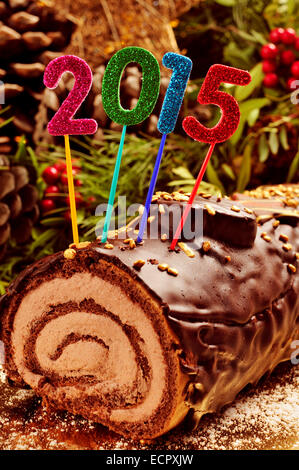 Une bûche de Noël gâteau traditionnel, de temps, avec des chiffres scintillants de couleurs différentes formant le nombre 2015, comme la nouvelle Banque D'Images