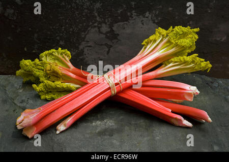 Rhubarbe fraîche lié en bottes et dans un panier trug. Tarte aux légumes Aliments rouge souvent utilisé dans les charlottes etc.une croix au Royaume-Uni Banque D'Images