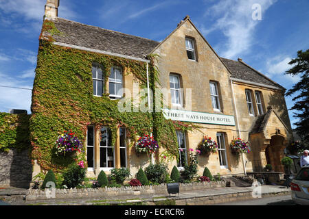 Un hôtel de campagne avec des murs couverts de lierre et un signe de maison de trois façons. Banque D'Images