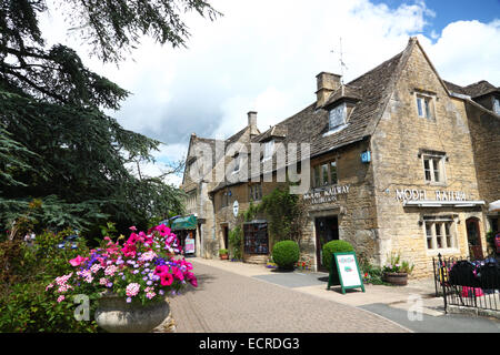 Une maison en pierre de Cotswold avec un modèle d'exposition ferroviaire signe. Banque D'Images