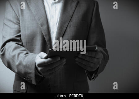 L'image affiche un individu vêtu d'un costume holding a tablet computer. Seule la personne à la taille du cou est visible dans la Banque D'Images