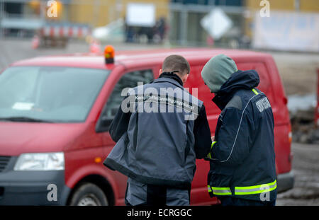 Potsdam, Allemagne. Dec 18, 2014. Un employé de l'élimination des armes et des munitions et de services d'un bureau de l'ordre public employé (R) examiner le site de découverte près de la gare centrale de Potsdam en Potsdam, Allemagne, 18 décembre 2014. Un avion de 250 kg de bombes de la Seconde Guerre mondiale a été trouvé à la gare centrale. Le unexploder bombe a été découverte au cours de travaux de construction. PHOTO : JULIAN STAEHLE/dpa/Alamy Live News Banque D'Images