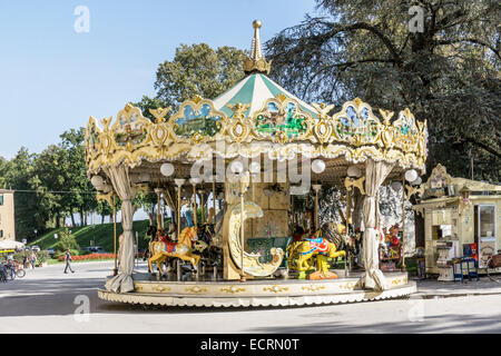 Petit faux vieux carrousel avec de la résine moulée animaux dans la Piazza Napoleone juste à l'intérieur de l'ancien mur de ville romaine fortifiée Banque D'Images