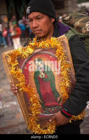 Un pèlerin marche portant une image de la Vierge de Guadalupe au cours du pèlerinage annuel à la basilique Notre Dame de Guadalu Banque D'Images