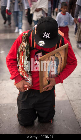 Un pèlerin marche transportant des images de la Vierge de Guadalupe au cours du pèlerinage annuel à la basilique Notre Dame de Guadalupe Banque D'Images