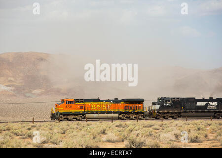 Un train passe par une tempête de poussière dans le désert de Mojave en Californie, USA. Banque D'Images