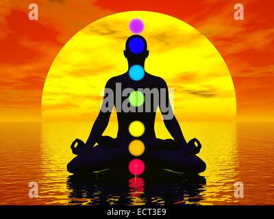 Silhouette d'un homme méditant avec sept chakras colorés à l'océan par red sunset Banque D'Images