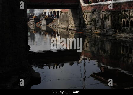 Reflet d'un sanctuaire hindou de temple de Pashupatinath et site du patrimoine mondial de l'Unesco dans les eaux de la rivière Bagmati à Katmandou Banque D'Images