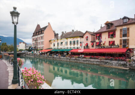 Joli panier de fleurs sur la rive de la rivière Thiou, restaurants et des auvents colorés sur fond, vieille ville, Annecy, France Banque D'Images