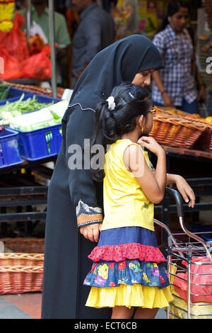 Robes Femme islamique dans un hijab avec Jeune Fille Shopping, Buffalo Road, Little India, à Singapour. Banque D'Images