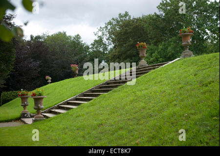 Garde des urnes plantées les marches de pierre qui mènent de la masse sur le plaisir plus jardins Banque D'Images