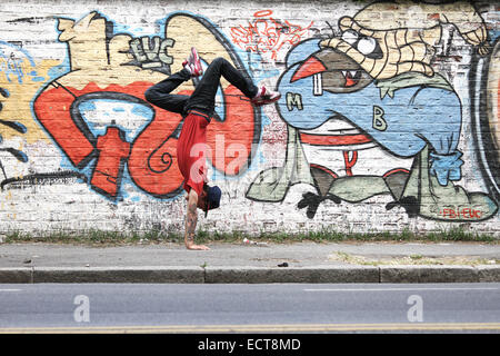 Un spectacle d'HipHop danseur en face d'un mur de graffiti. Banque D'Images